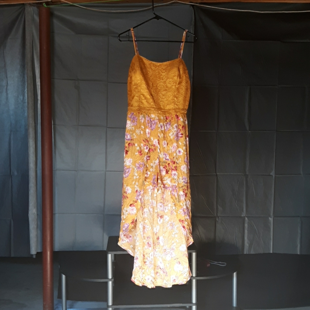 A mustard colored Romper with a floral design